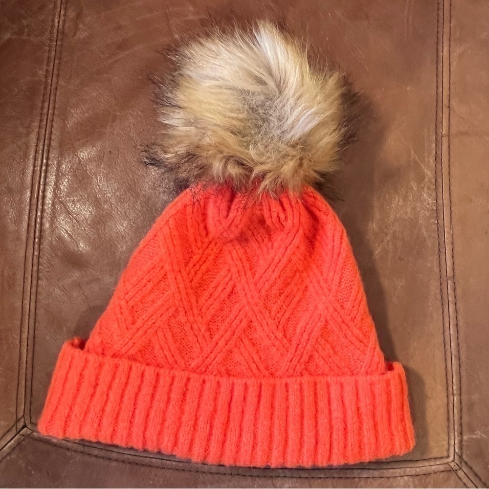 Orange winter ski hat toque with fur pom pom.